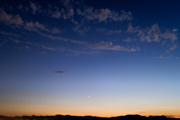 Beautiful sunset behind the mountains with the dark sky and romantic atmosphere.
