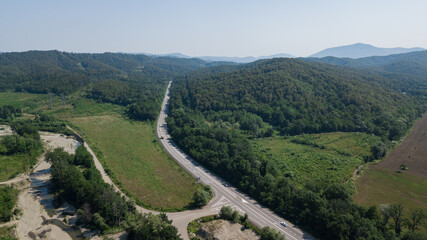 Fototapeta na wymiar Aerial view from above of curve highway road with a car with green forest in Russia