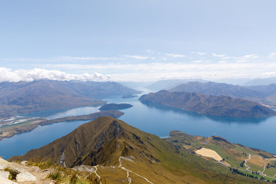 The View From The Summit Of Roys Peak Over Lake Wanaka And The Mountains Of The Southern Alps As Clouds Roll Over Them.