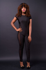 Young beautiful African woman against black background