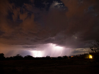 Naklejka na ściany i meble A dramatic desert monsoon storm at night with lightning