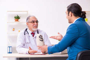 Young businessman meeting with old doctor