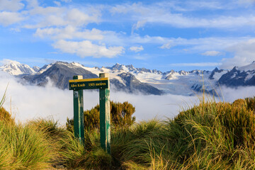 The summit marker for Alex Knob with Franz Josef Glacier obscured by a cloud inversion. Franz Josef Glacier, South Island, New Zealand