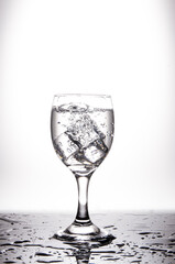 The bubbles in the wine glass are placed on a black glass floor. Caused by ice cubes that are extremely cold