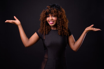 Young beautiful African woman against black background