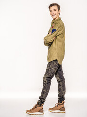 Fototapeta premium Smiling young man in camouflage clothing. Happy Conscript in camouflage. Cheerful rookie in army clothes. Teenager in khaki military clothing.