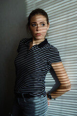 portrait of a girl with a shadow from the blinds, low key