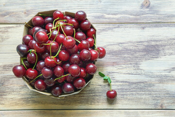Cherries from market.  Fresh ripe fruits in cardboard box on rustic table. Flat lay. Free space for text