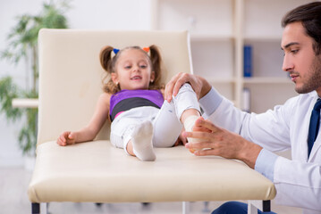 Small girl visiting young male doctor