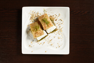 Turkish puff baklava with ice cream on square plates, top view. Turkish sweetness. Photos for restaurant and cafe menus