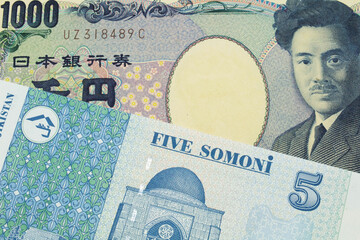 A macro image of a Japanese thousand yen note paired up with a blue and white five somoni bank note from Tajikistan.  Shot close up in macro.