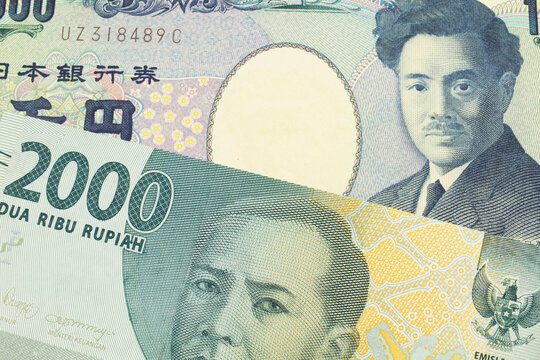 A macro image of a Japanese thousand yen note paired up with a grey two thousand rupiah bank note from Indonesia.  Shot close up in macro.