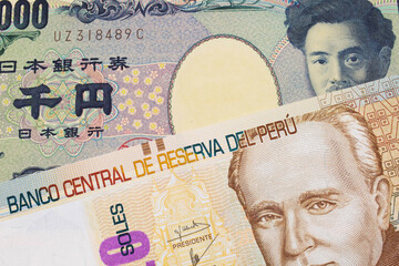 A macro image of a Japanese thousand yen note paired up with a beige, twenty sol bill from Peru.  Shot close up in macro.