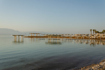 Obraz premium early morning on the sea in the distance you can see the awnings from the sun on the bend of the beach