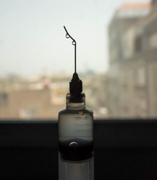 macro photo of water drop on the tip of needle