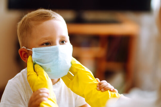 Little Boy In Sterile Medical Mask  Plays Constructor At Home  With Man In Protective Hazmat Suit During Pandemic. Covid-2019. 