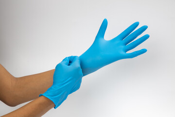 Female hand wears a protective glove for cleaning or tidying. Woman's hand latex glove gesture isolated on white. Female hand putting on latex glove isolated on white background