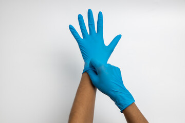 Female hand wears a protective glove for cleaning or tidying. Woman's hand latex glove gesture isolated on white. Female hand putting on latex glove isolated on white background