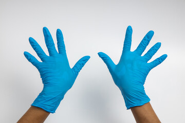 Woman hand wearing a blue rubber medical glove on white isolated background.