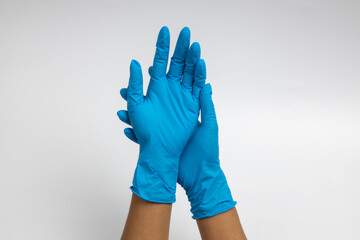 Woman hand wearing a blue rubber medical glove on white isolated background.