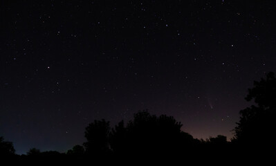 Comet Neowise in the black starry night sky. The sky of the Northern hemisphere at night, various constellations, comets and cosmic celestial bodies. Night sky, space.