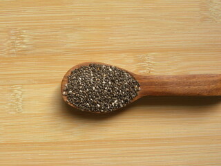 White and black color raw Chia seeds or Salvia hispanica on wooden spoon