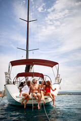 Friends chilling on stern of a yacht