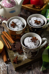 Autumn apple pie mugcake with red apples and spices on a rustic background.