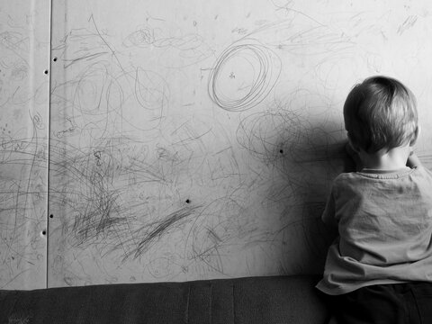 little boy draws on the wall