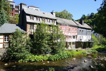 Monschau, Germany (Eifel) - July 9. 2020: View on river with timber frame monument houses in center of medieval village