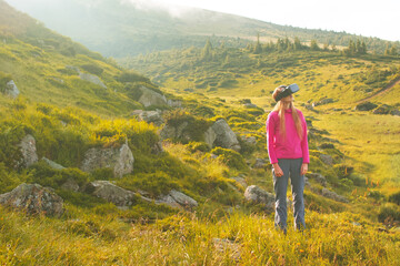 Fototapeta premium Woman in virtual reality glasses standing near a mountain lake