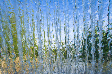 The texture of a transparent water wall from jets of water flows down. Close-up view
