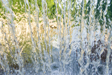 The texture of a transparent water wall from jets of water flows down. Close-up view