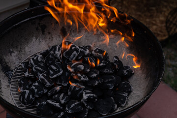 Close-up of a blazing fire in rustic BBQ grill at the evening.