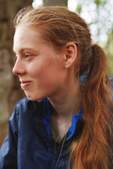 Young blonde woman tourist resting on a hiking backpack in the mountains