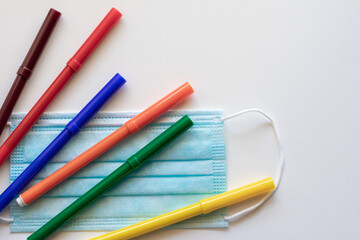Naklejka premium Colored markers along with a mask, mandatory in many countries to prevent covid 19 infections in schools