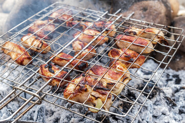 Juicy meat steaks cooked over charcoal on a wire rack. Meat cooked on a fire in the open air. Selective focus. Close-up.