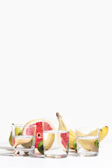 Fruit banana, pear, kiwi and grapefruit distorted through glass water on white background. Modern food still life