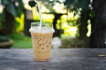 ice coffee on wooden table. in a garden cafe.