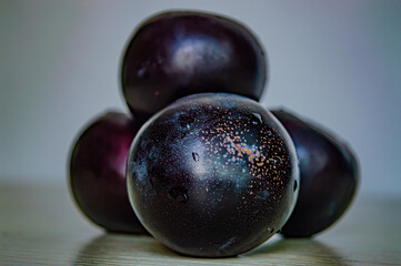 purple ripe plum closeup on white fruit background