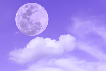 Full moon with blurred clouds on purple sky.