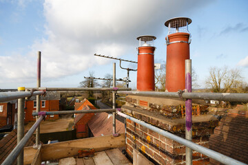 Chimney pots and scaffolding during construction work, UK