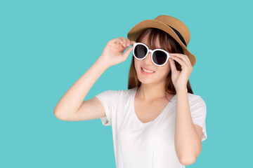 Beautiful portrait young asian woman wear hat and holding sunglasses smiling confident enjoy journey summer trip in vacation isolated on blue background, tourist asia girl cheerful with travel.