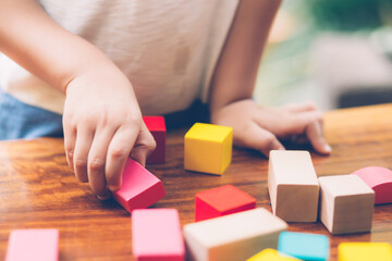 Closeup hand of boy playing wooden block toy on table for creative and development with enjoy, happy child learn skill for activity puzzle and creativity for game on desk at home, education concept. - Powered by Adobe