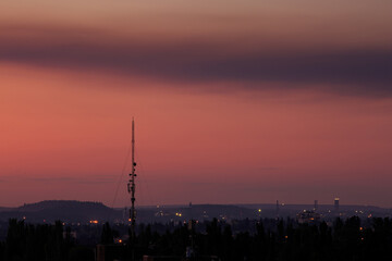 Silhouette of mobile communication antenna in the city at sunset or sunrise