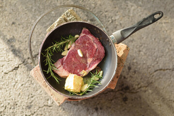 Tasty Beef steaks grill by using butter instead the oil on the pan above charcoal stove with herb ingredient