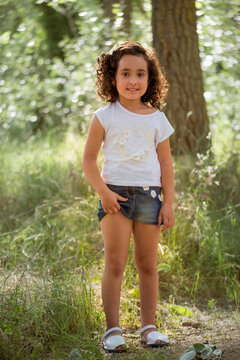 Girl In White T-shirt And Denim Miniskirt Posing Inside A Grove.