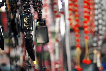 Black crystal nail pendant necklace with beads and soft focused colorful background .selective...