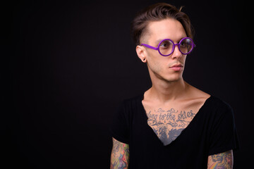 Obraz premium Young handsome rebellious man against black background