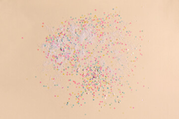 orange background in pastel colors, round sparkles and shiny sand are scattered in a circle